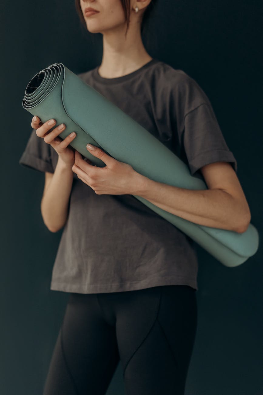 crop photo of woman with yoga mat